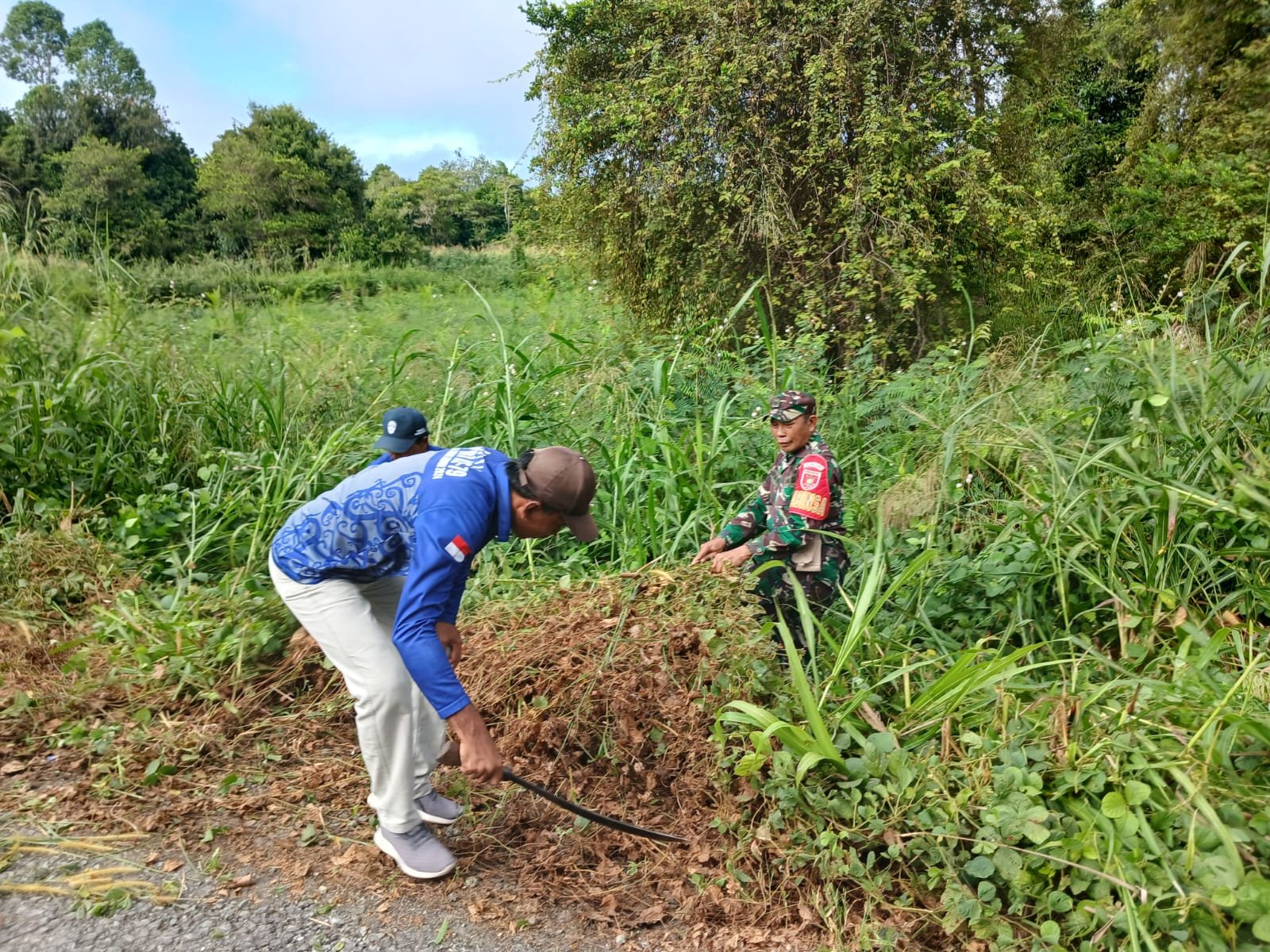Semangat Jumat Bersih, Babinsa Bersama Warga Gotong Royong Bersihkan Tanaman Liar di Sepanjang Jalan Desa